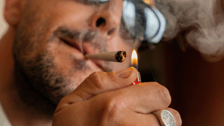 Man with sunglasses lighting a THCA joint